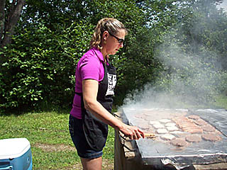 woman grilling burgers at the picnic