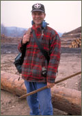man standing in front of log