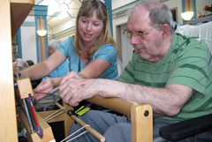 Artist helps senior resident with a weaving project